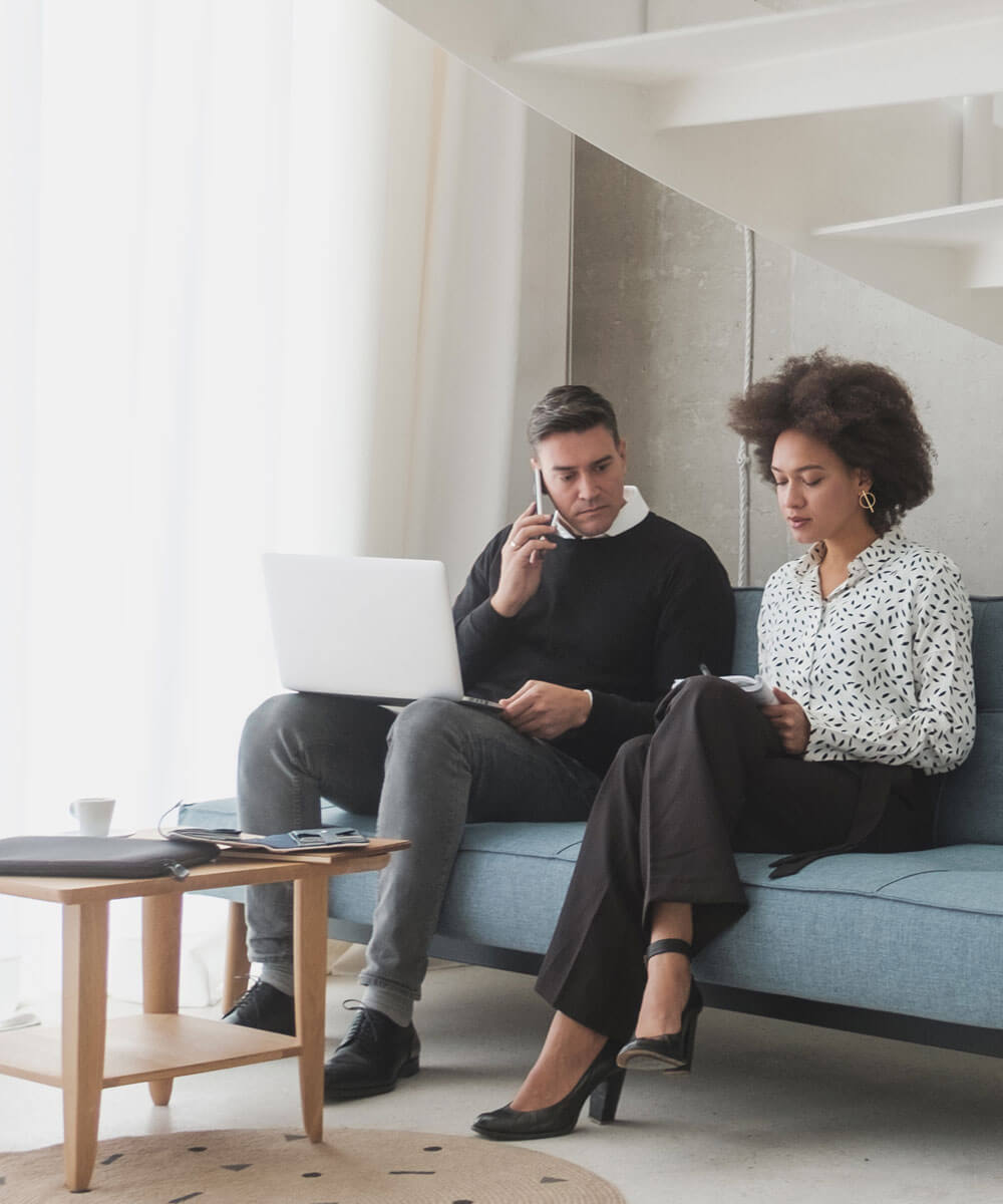 Two people sitting on a couch working on Canvas