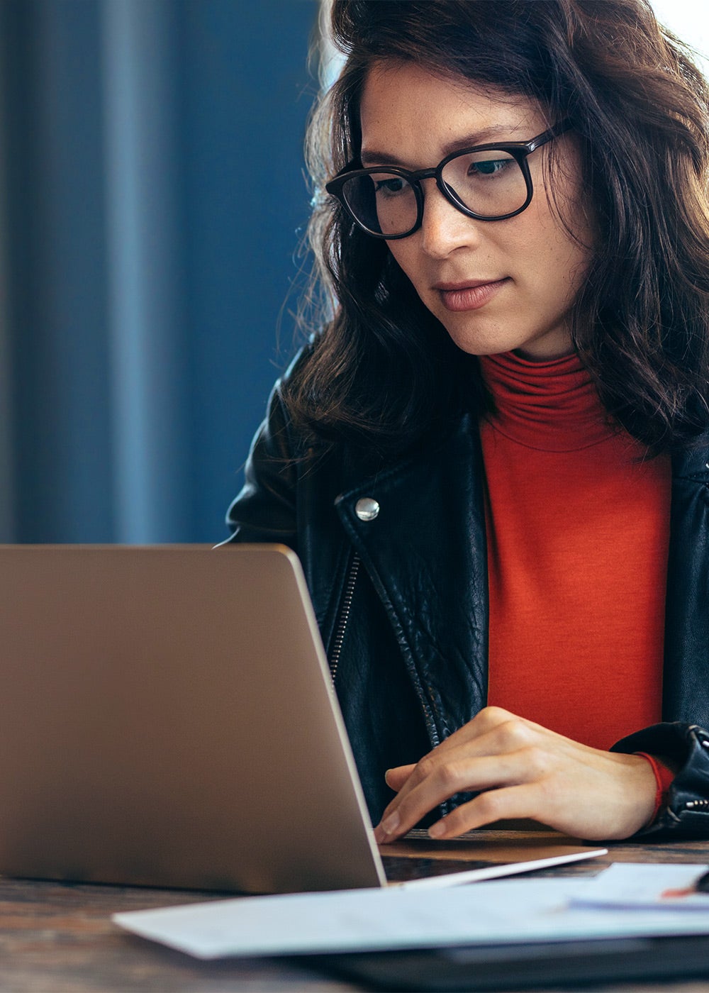 Woman with glasses working at laptop