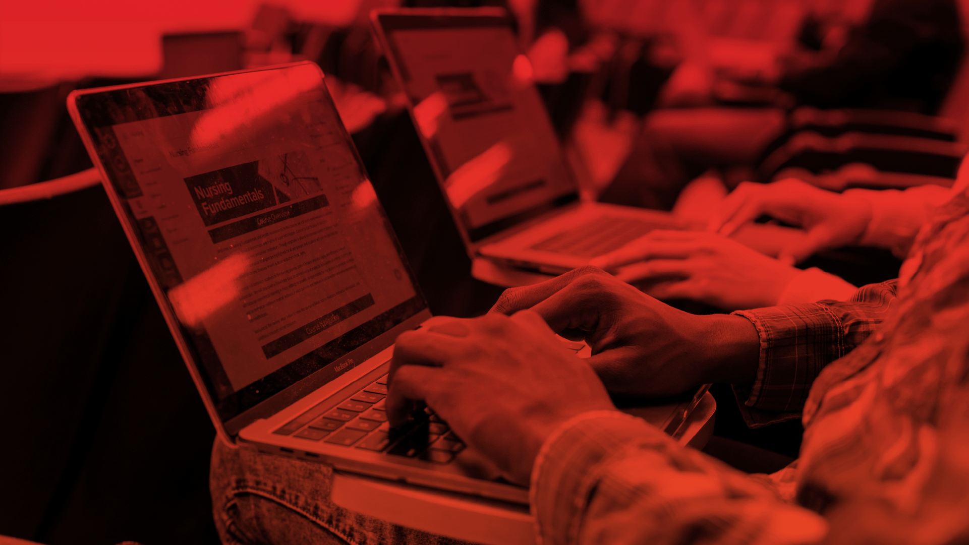 Students opening Canvas on their laptops while on class