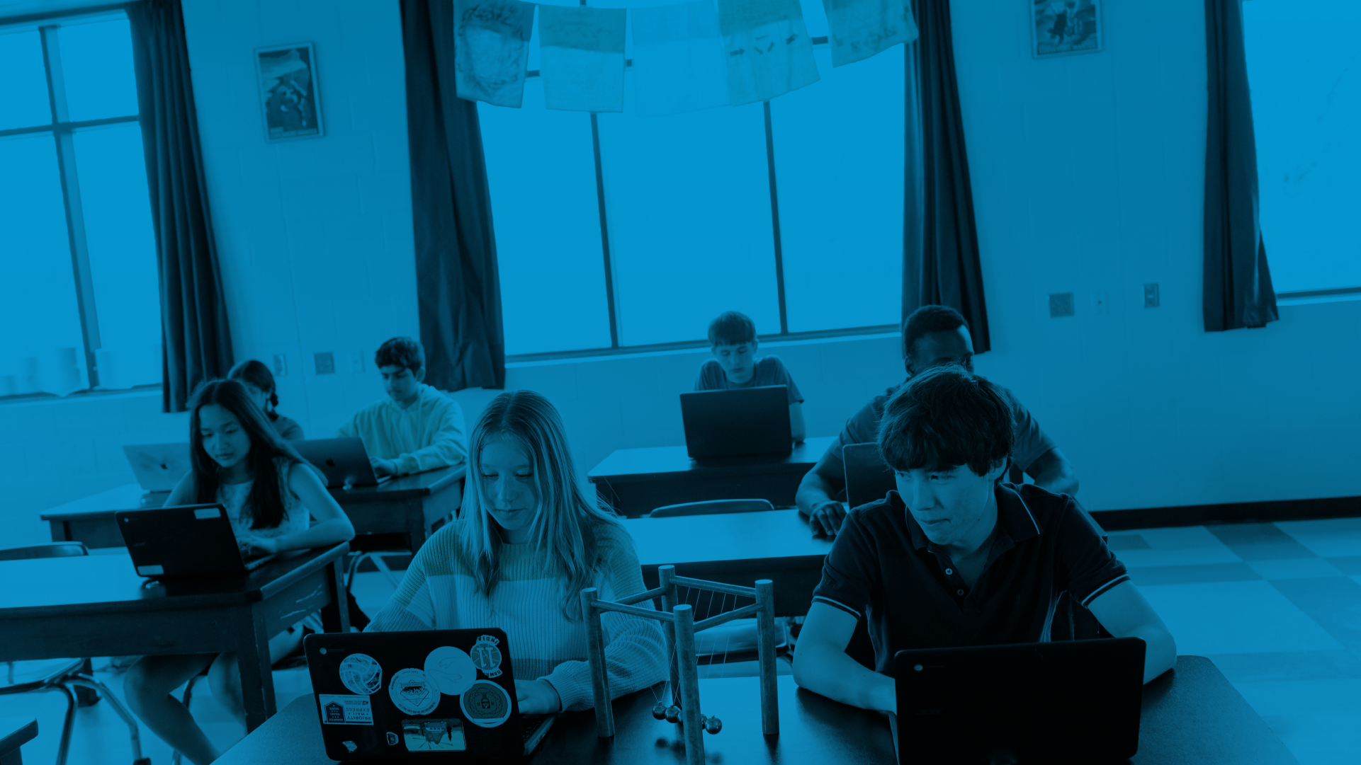 Students sitting in a classroom using laptops