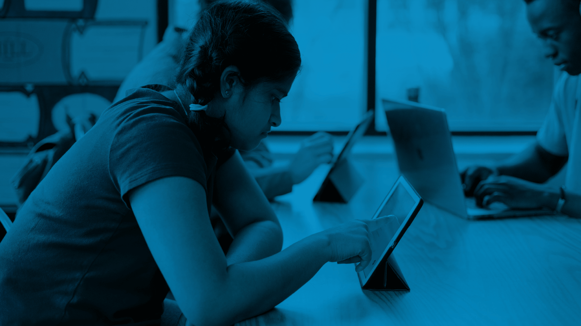 A group of people using tablets and a laptop