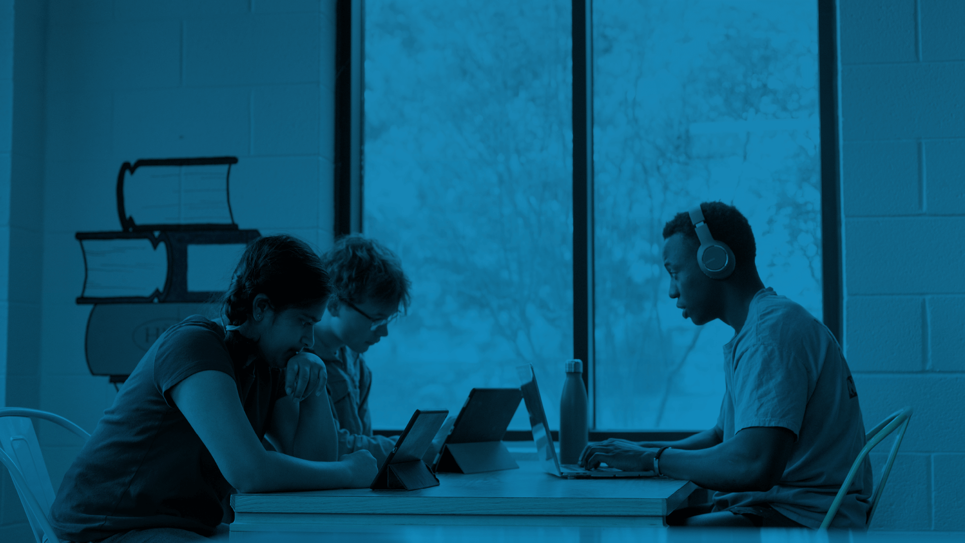 A group of people using tablets and a laptop