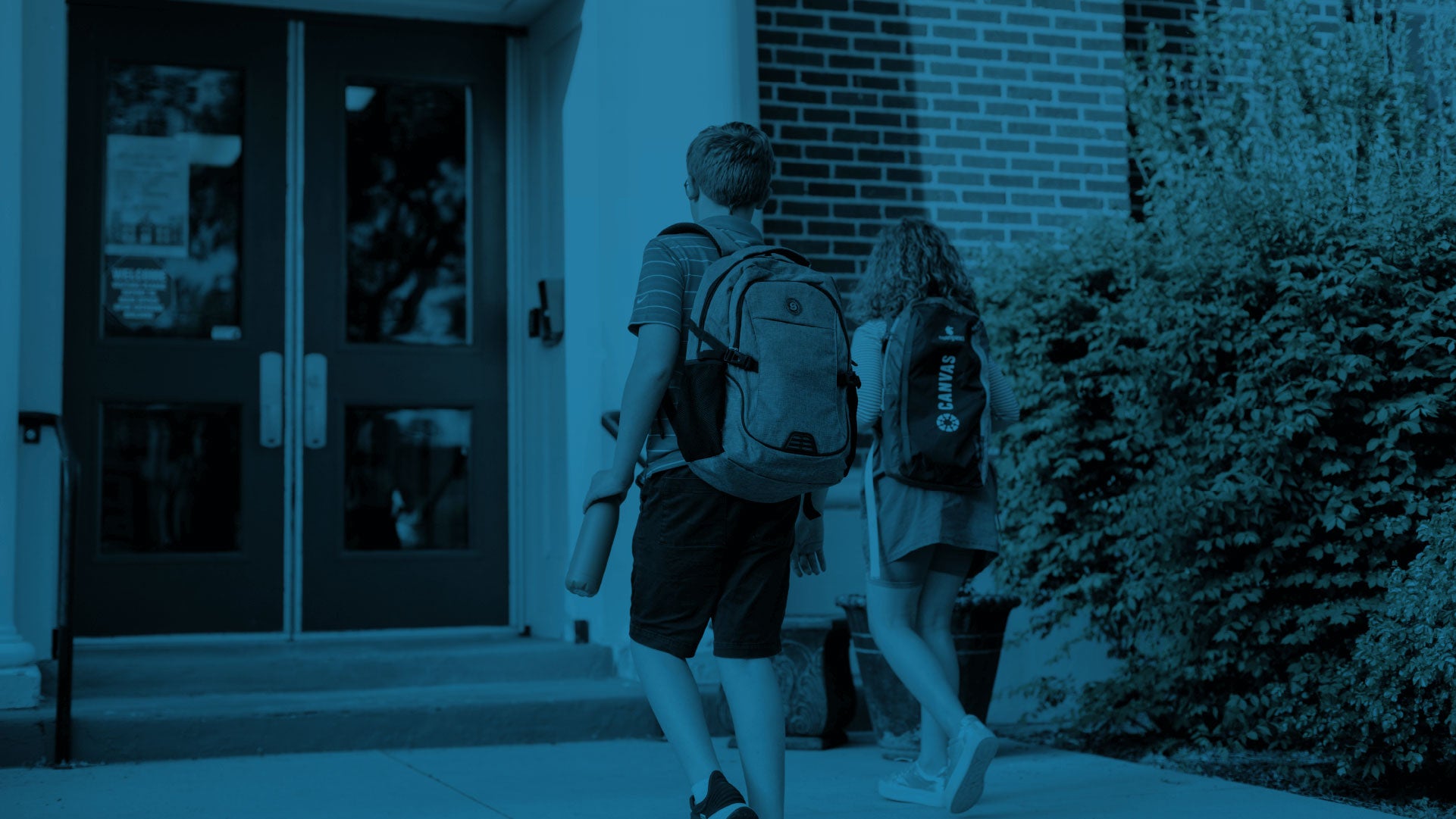 Two students wearing a backpack while going to school