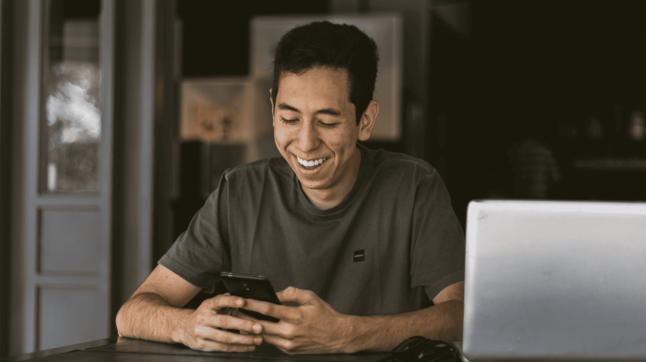 man smiling while using a cellphone