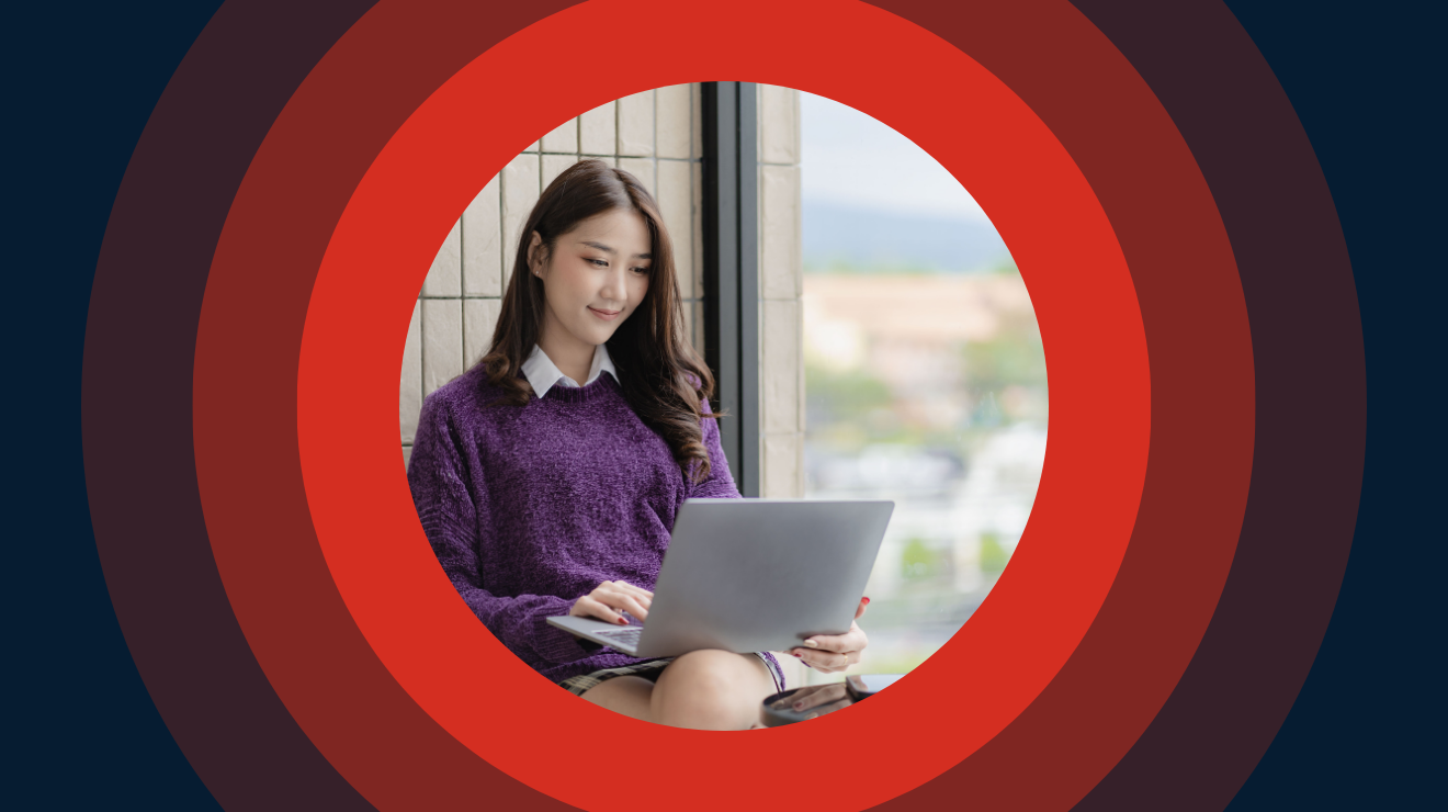 A woman on a bench with a laptop, engaged in work or study in a serene outdoor environment.