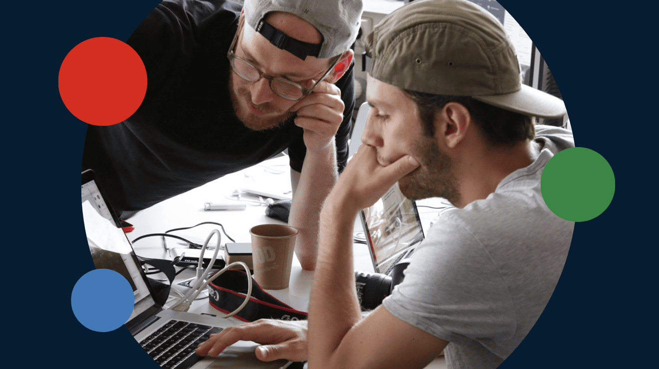 two men looking at a laptop