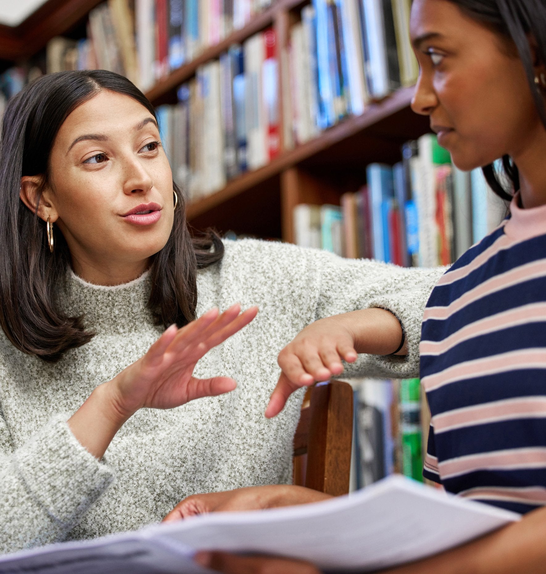 Students discussing course work in a school library