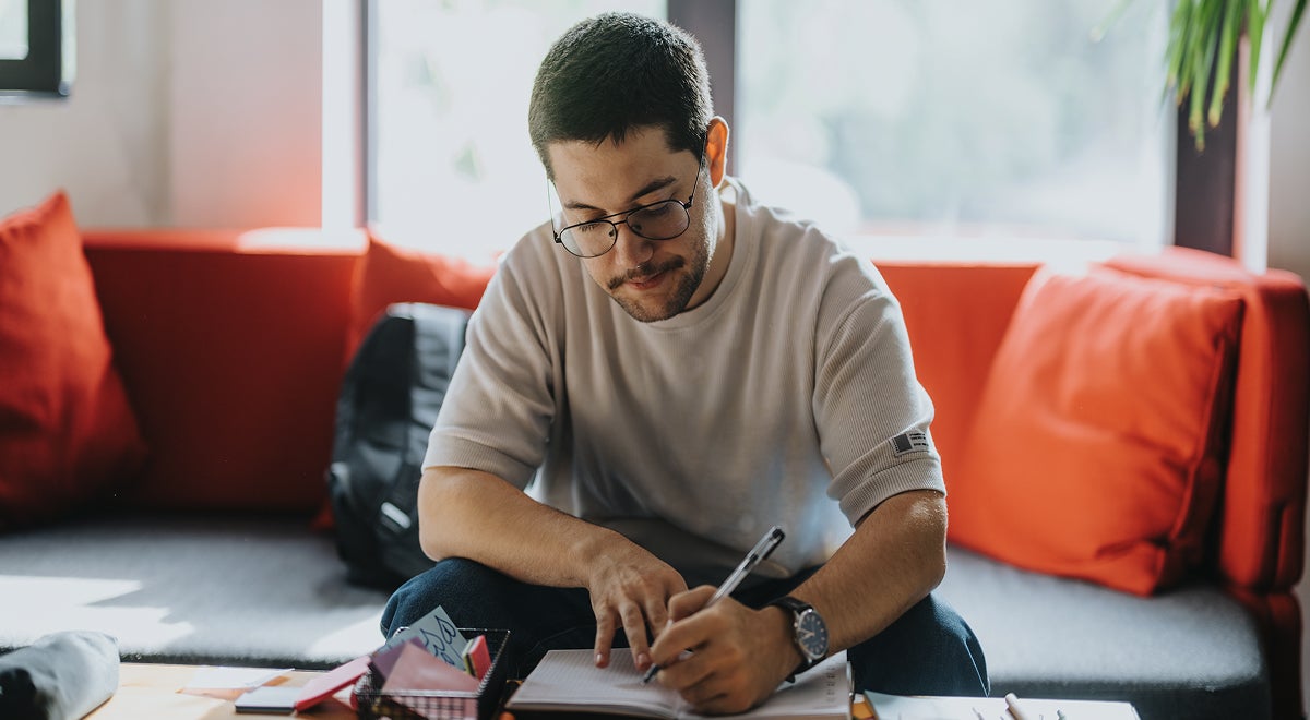 A man writing on a notebook