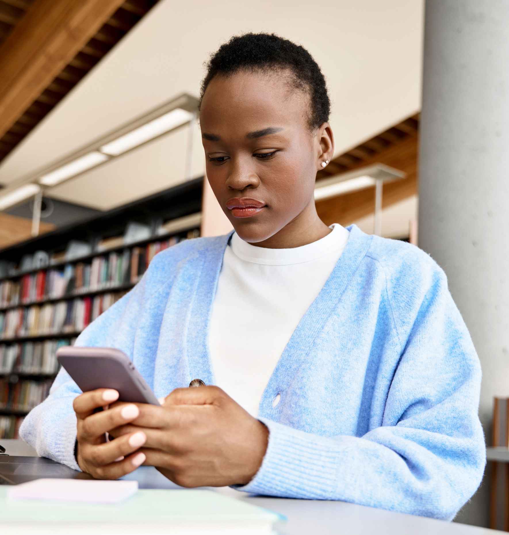 A student using her phone in a library