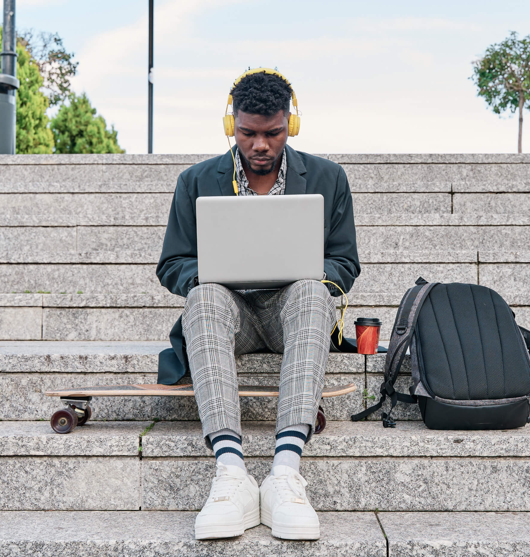 A college student using a laptop and headphones to study