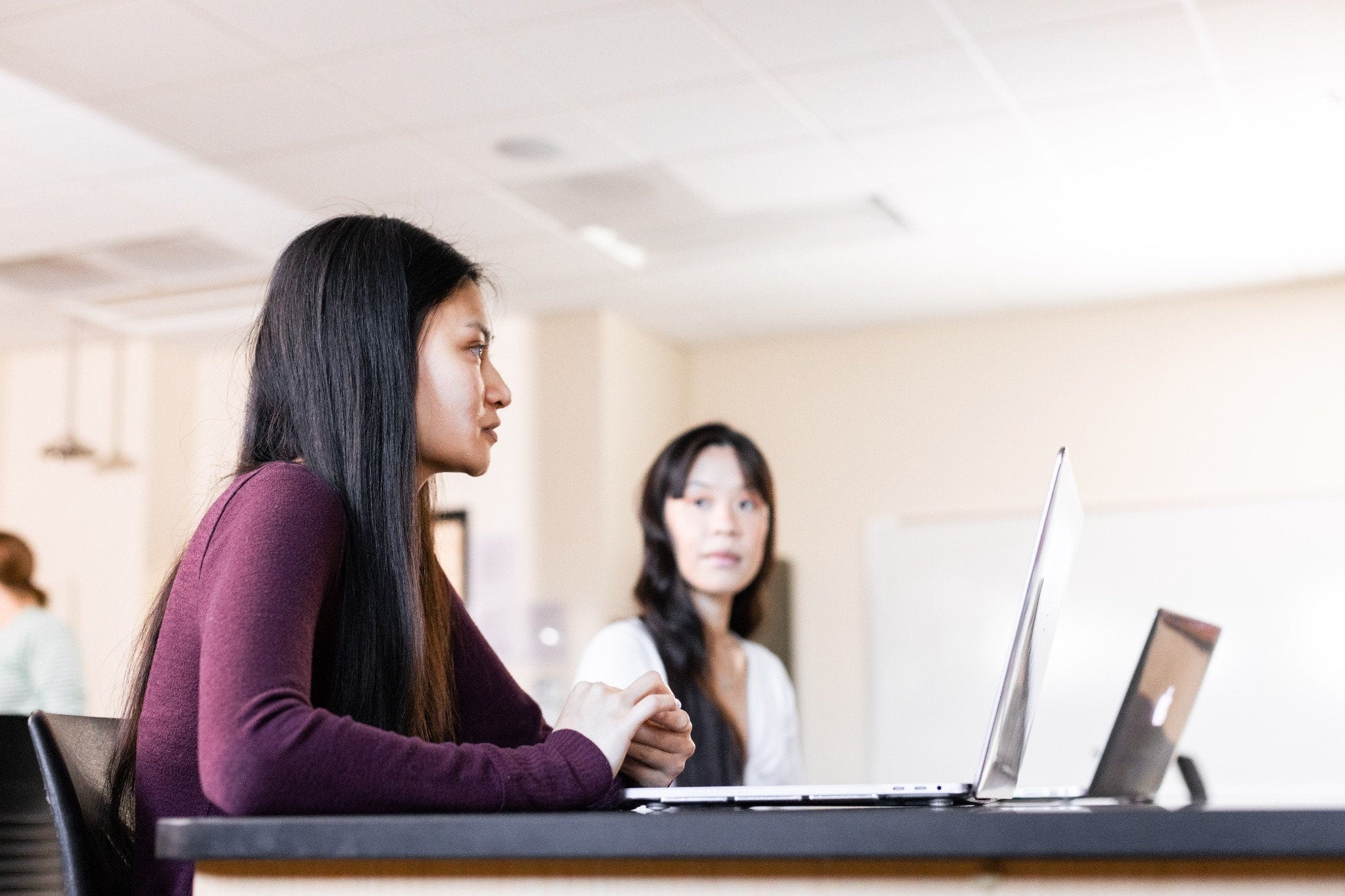 Students studying in a classroom on a laptop