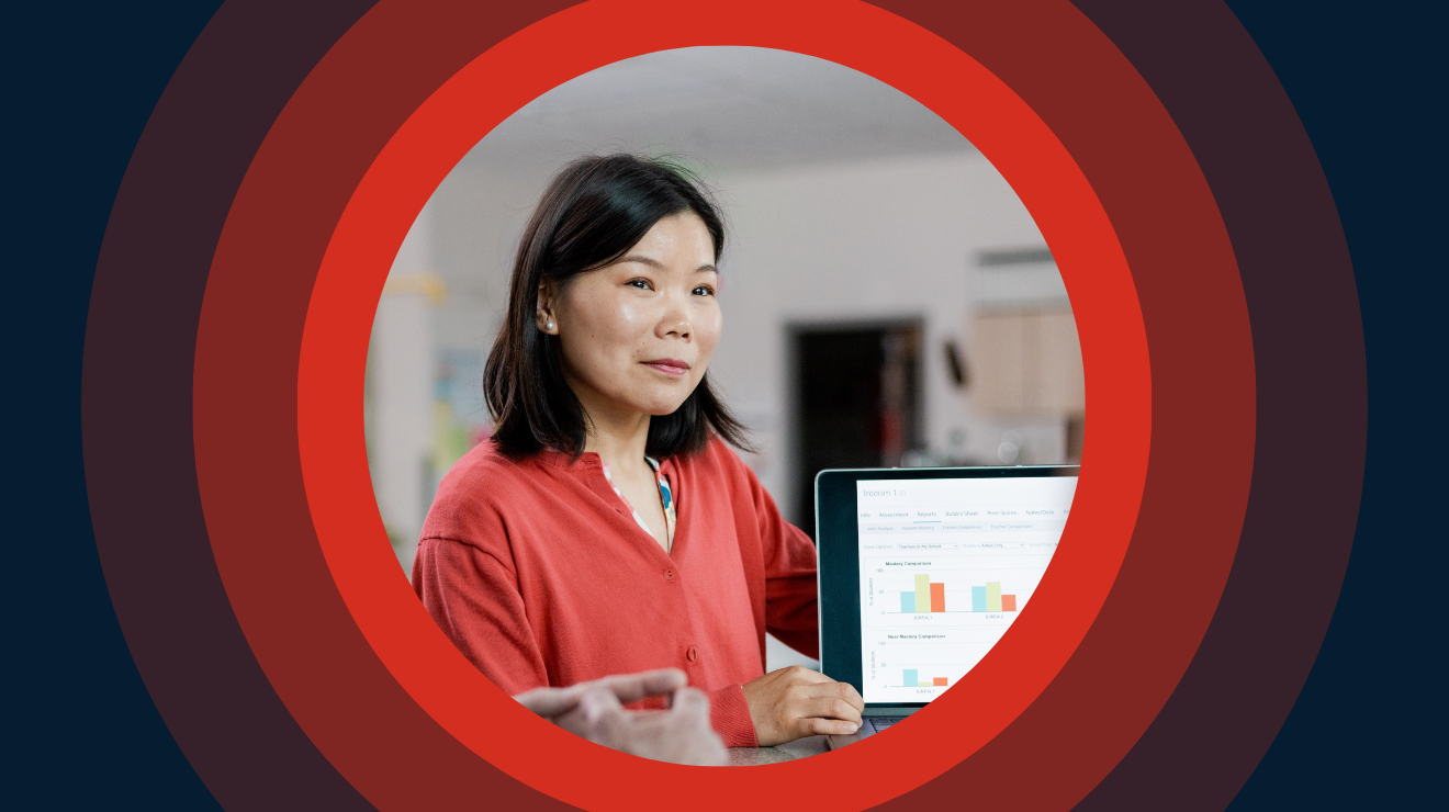 Lady in red blouse sits next to open laptop