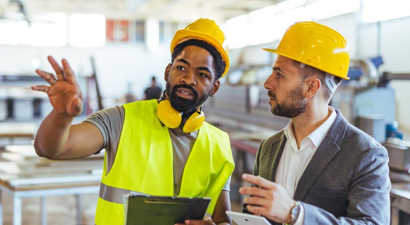 Co-workers discussing something on a job site