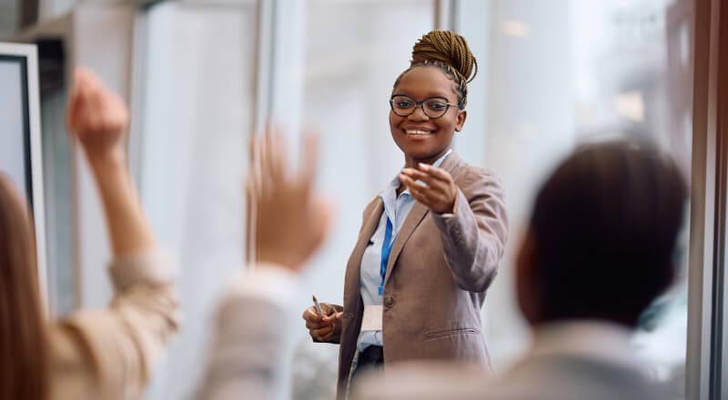 A teacher calling on students with raised hands