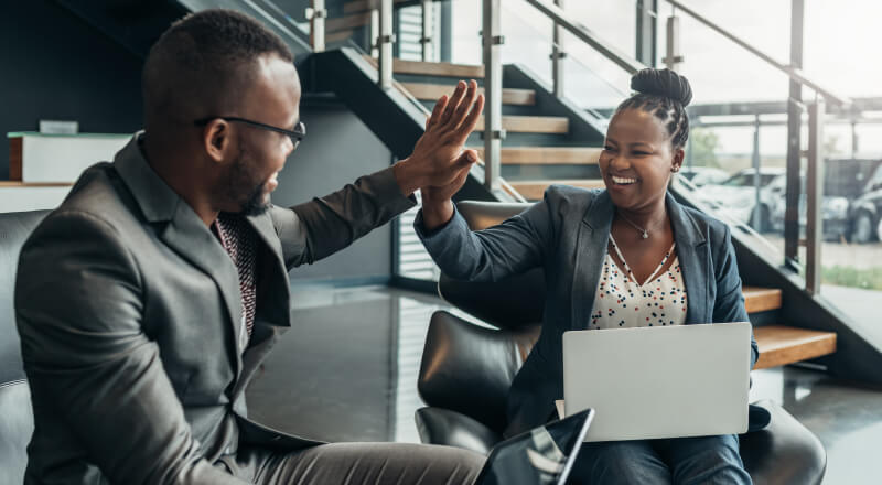 Co-workers high-fiving in a lobby