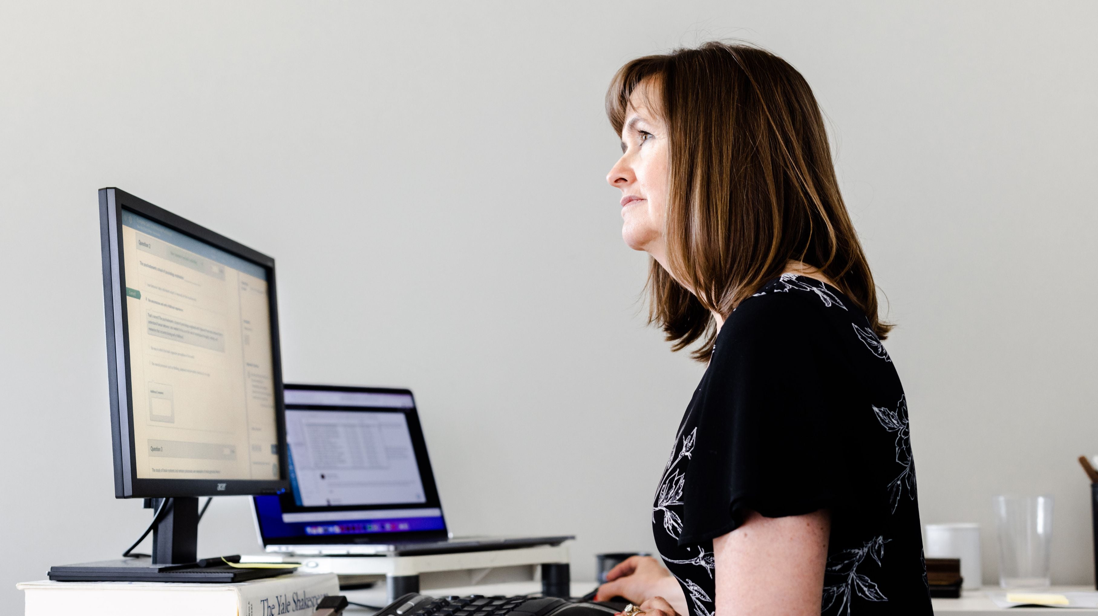 a staff member reviews information on her computer at her desk
