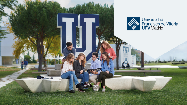 Some students sitting next to a large U and the Universidad Francisco de Vitoria logo.