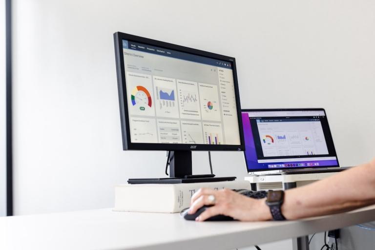 Eye-level view of someone using a two monitors at a desk