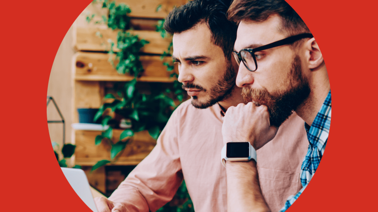 two men looking at a laptop