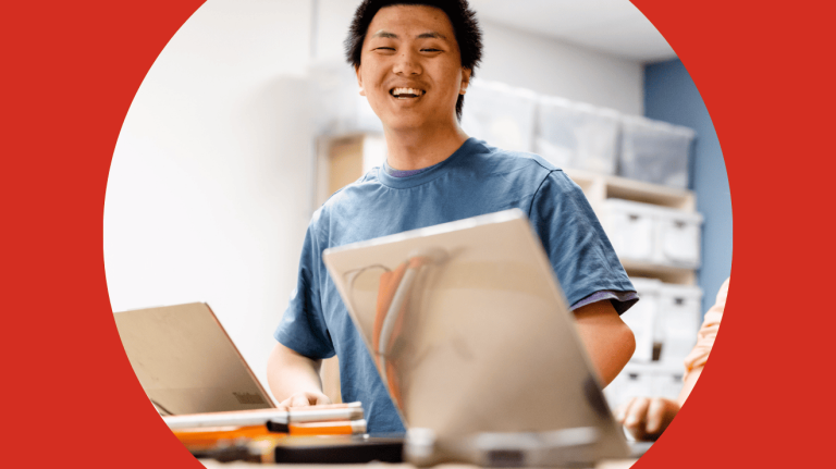 A man is engaged with his laptop in a bright, modern workspace.