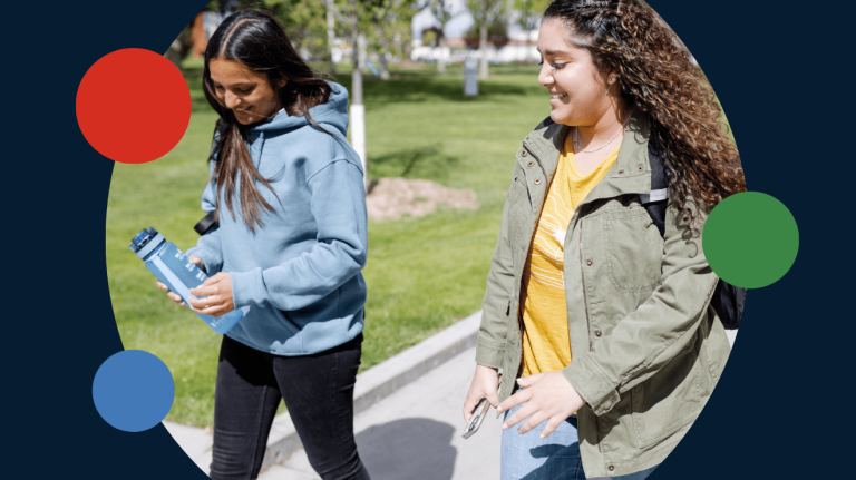 Two women are walking on a sidewalk
