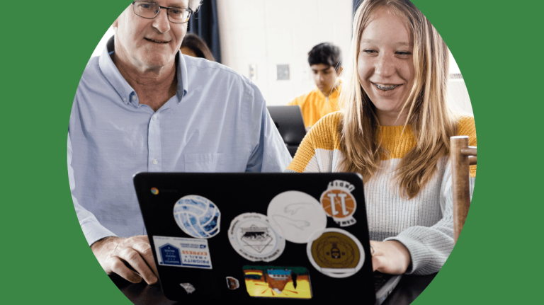 A man and woman are focused on a laptop screen, engaged in discussion or collaboration.