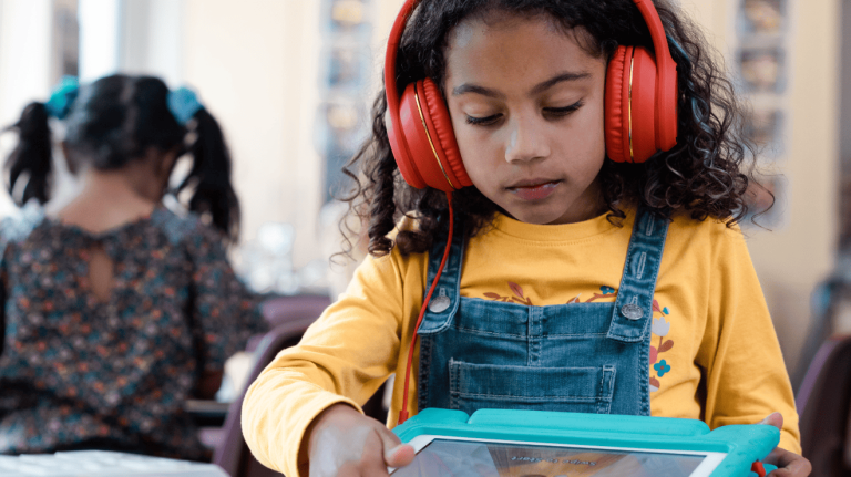A young girl wearing red headphones