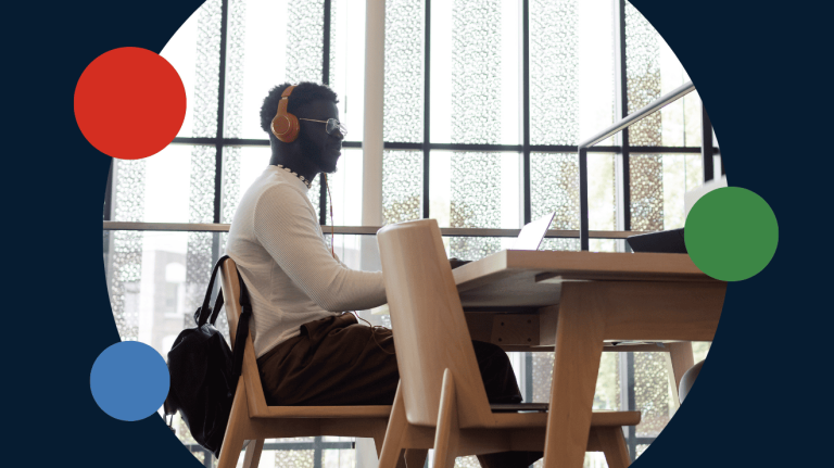 A man with headphones sits at a desk