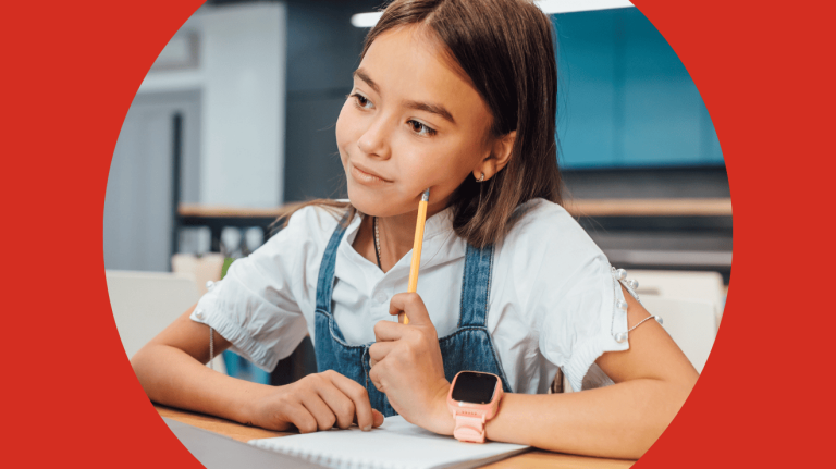 A girl sitting at a desk, holding a pencil, focused on her work.
