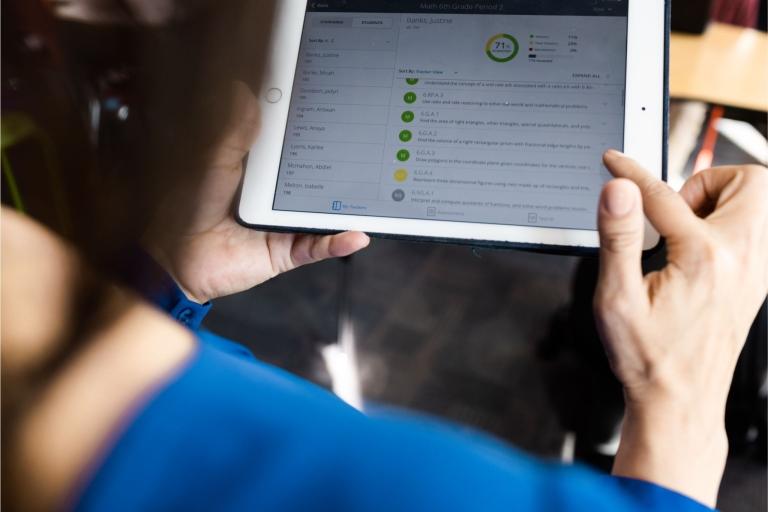 An educator looks at data on a tablet
