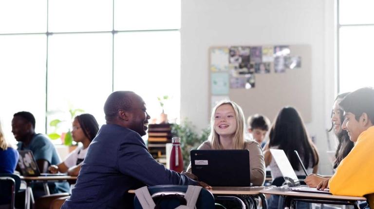 teacher talks to students in a classroom