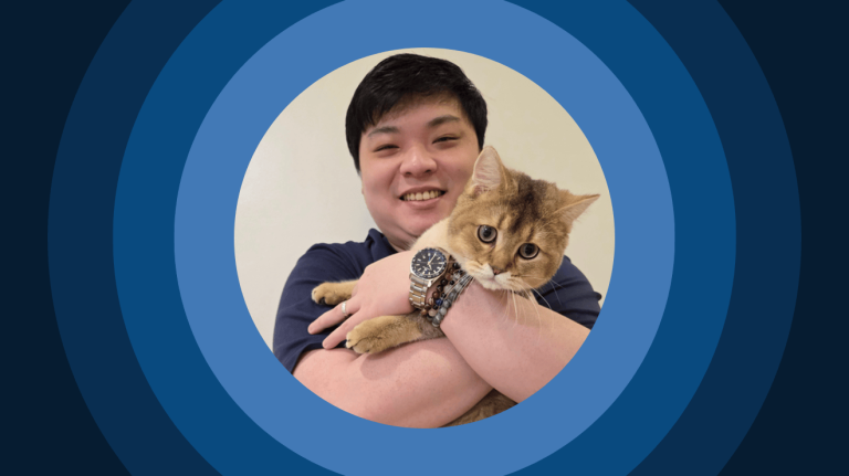 Image of Solutions Engineer Aric Lim embracing his cat