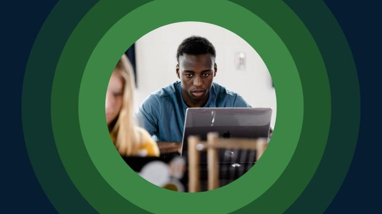 a student takes an assessment on a laptop in a classroom