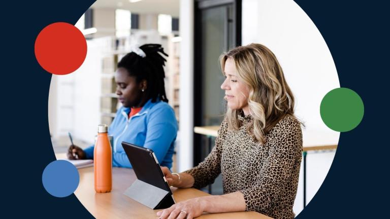 two faculty members work at a table