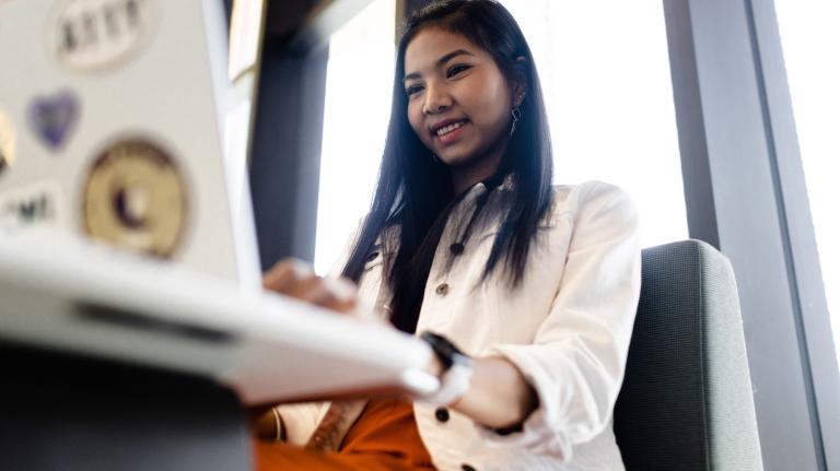 a student works on a laptop in a higher ed library