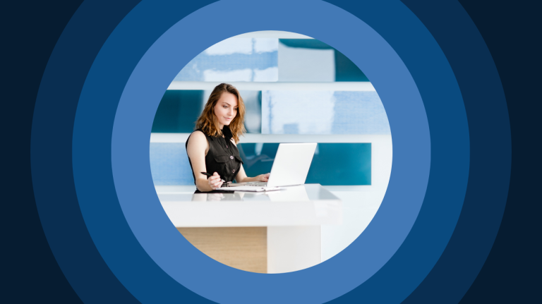 a woman works at a laptop in an office