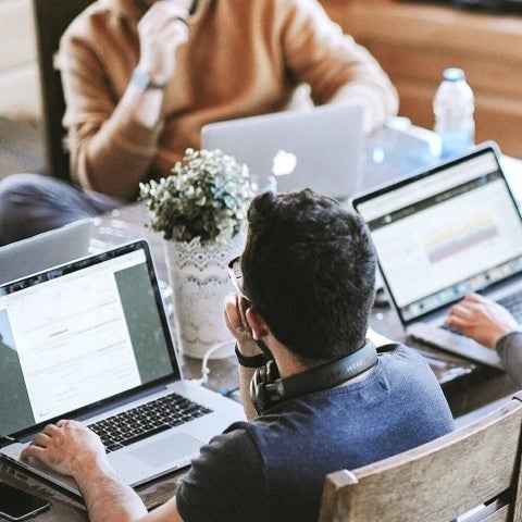 Students working on laptops at table together