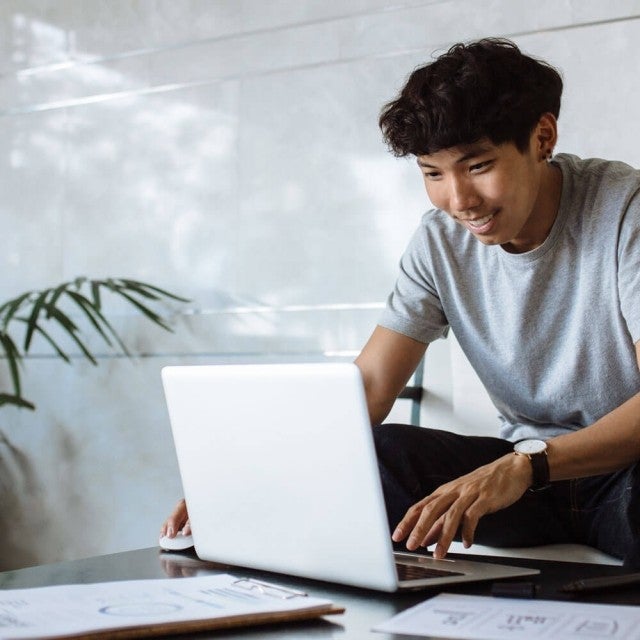 person working on laptop on a coffee table smiling