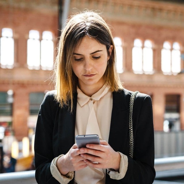 Person at train station looking at phone