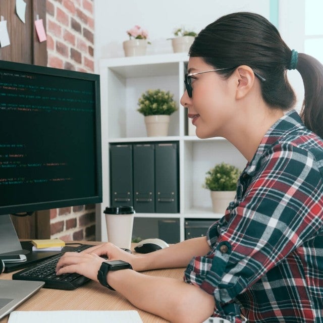 Person sitting in office working on desktop computer