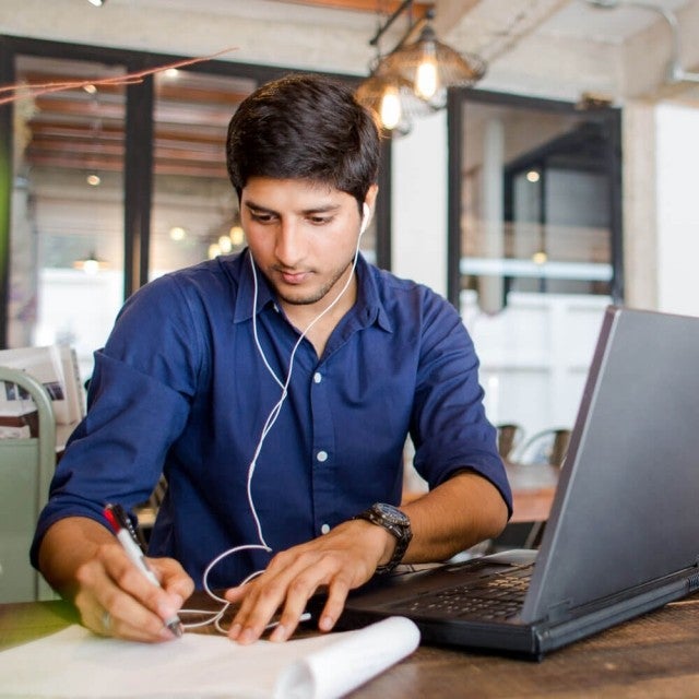Person working at table with headphones on
