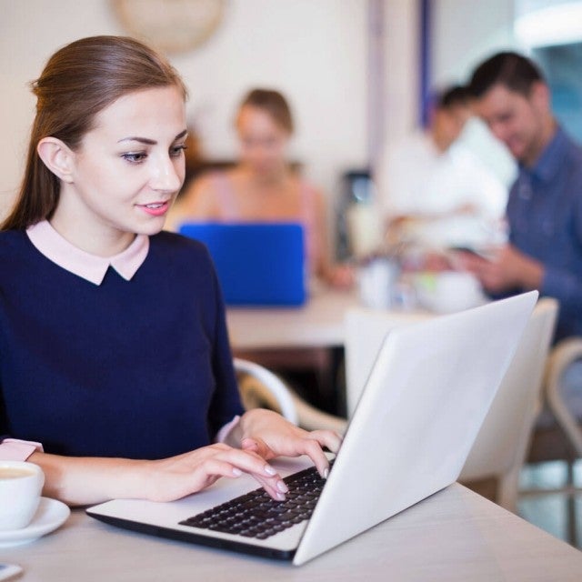 Person sitting in cafeteria working on Canvas
