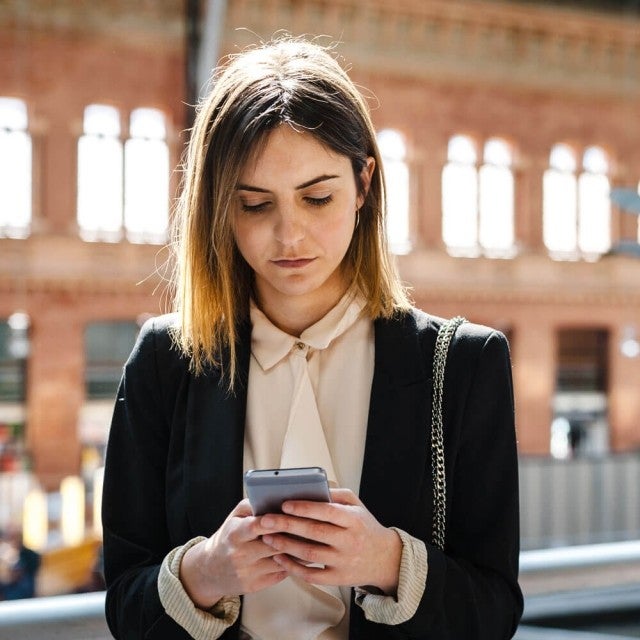 Person at train station looking at phone