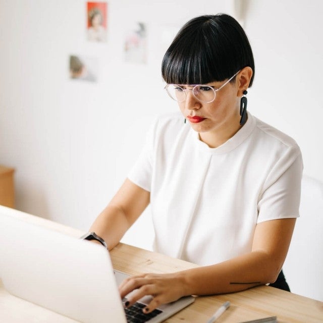 Person sitting at table working on laptop