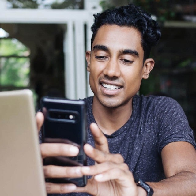 Person sitting outside looking at phone