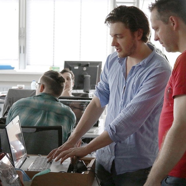 Two people working together on laptop in office