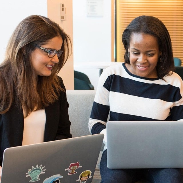 Two people in school working on laptops