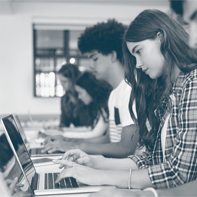 K12 Assessments image of students on laptops