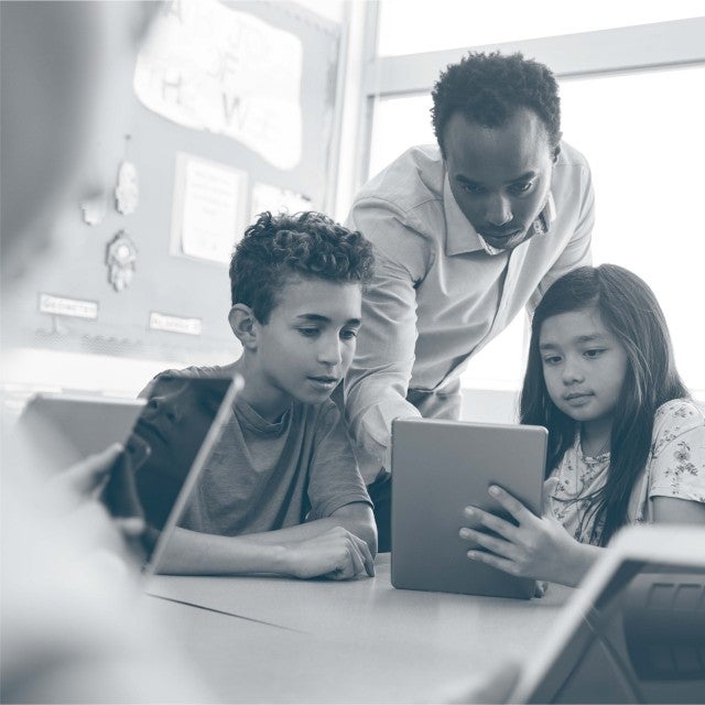 K12 Assessments image of teacher instructing students using tablet