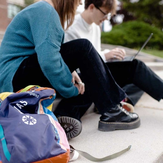 Two students sitting on steps opening LearnPlatform on the laptop